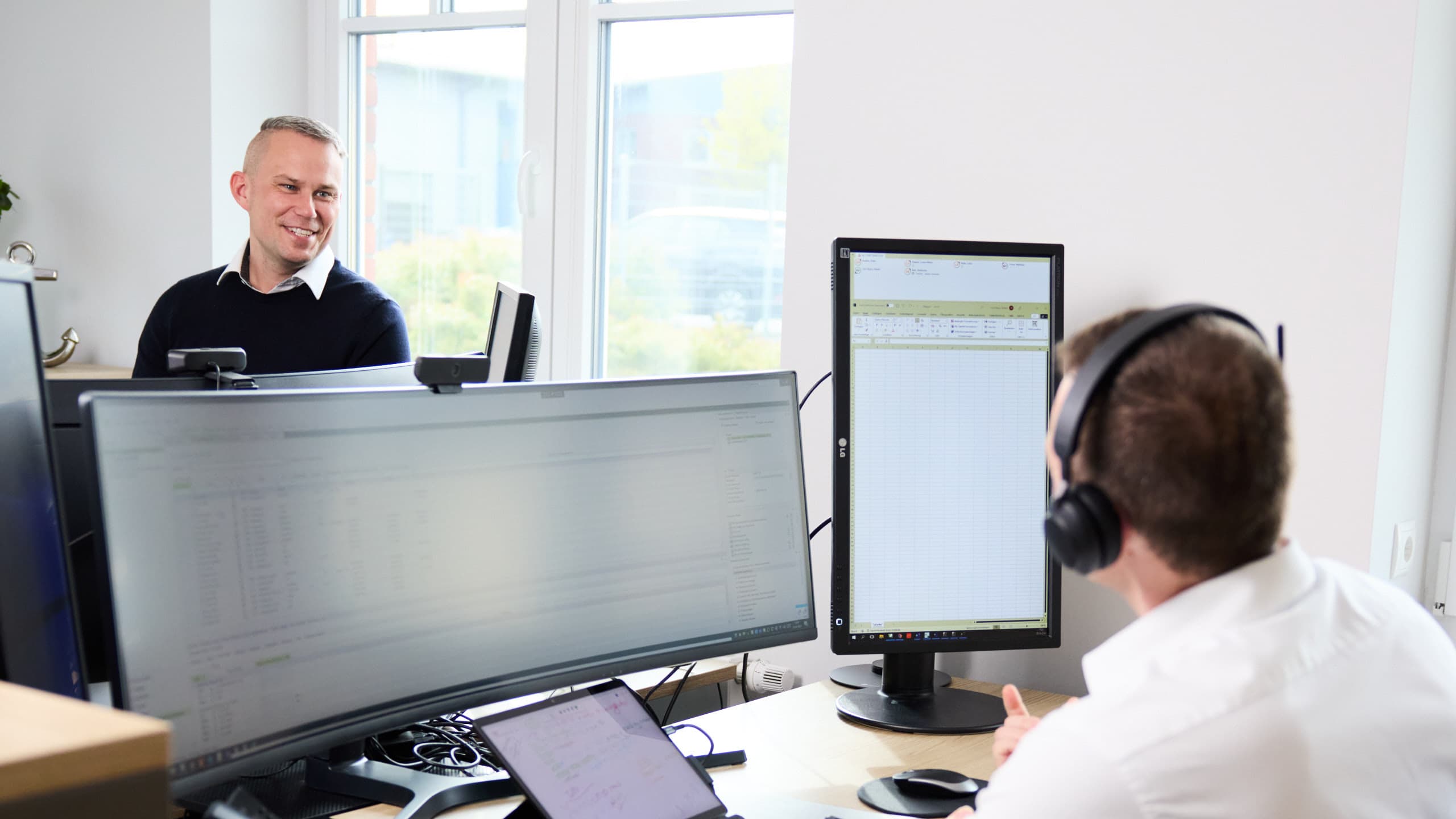 Matthias Timm und Rafael von Heyer an ihren digitalen Arbeitsplätzen in der Kanzlei