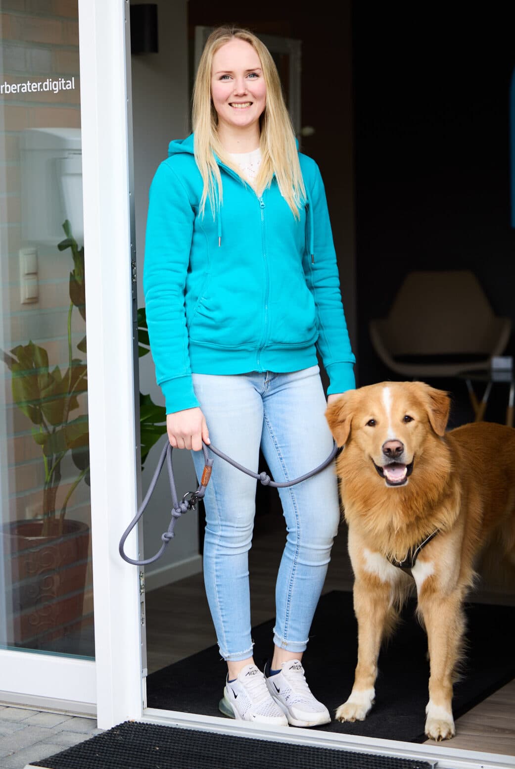 Eine Kollegin mit ihrem Bürohund am Eingang der Kanzlei